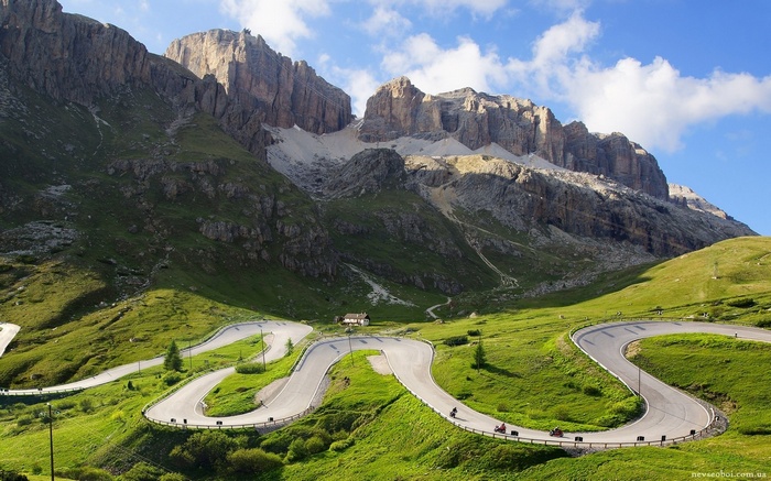 Winding mountain road with motorcyclists and large rock formations