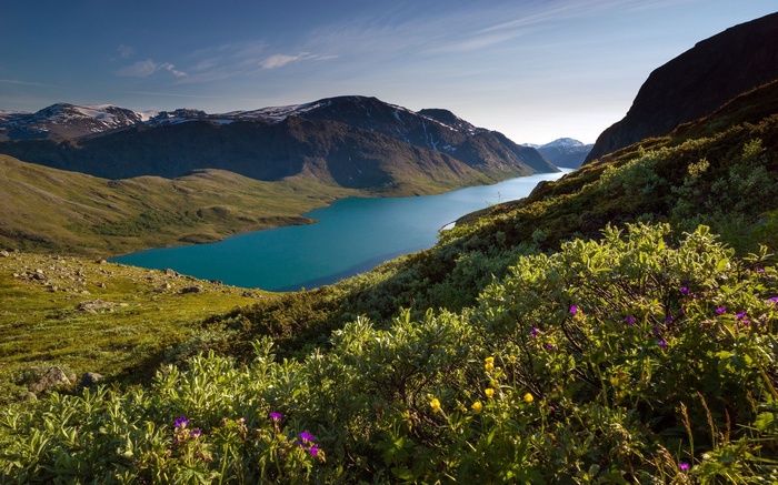 Turquoise lake surrounded by mountains and green hills