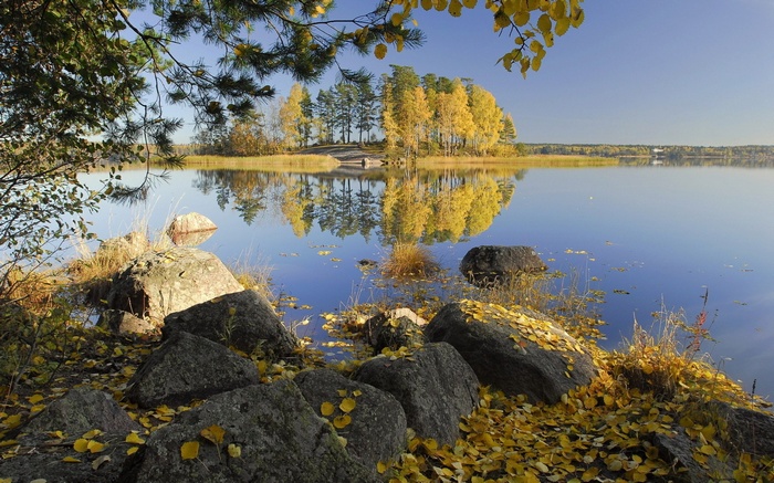 Autumn lake with yellow trees and rocks