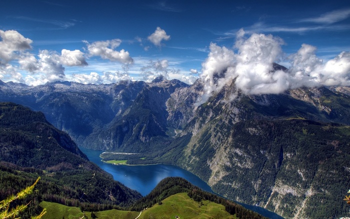 Lake surrounded by mountains under a cloudy sky