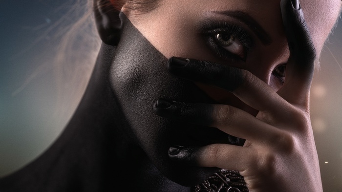 Woman with black body paint covering her face