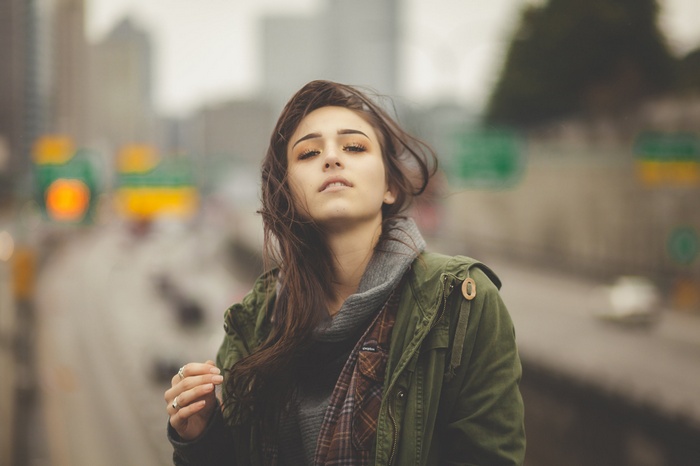 Woman in jacket touching her hair outdoors