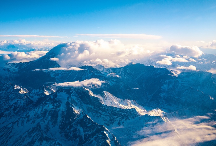 Aerial view of snow-capped mountains under a blue sky