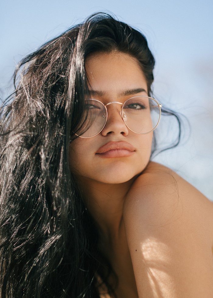 Woman with long dark hair and glasses