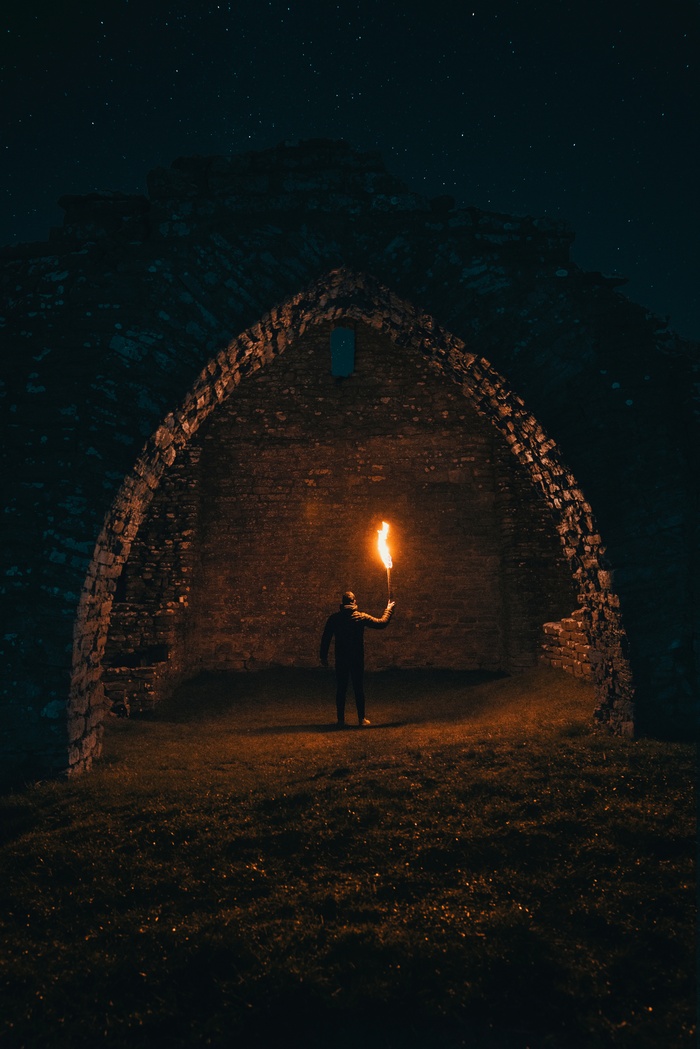 Man holding torch in ancient ruins at night