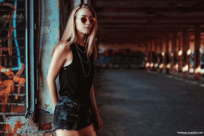 Woman with sunglasses and jean shorts in urban setting