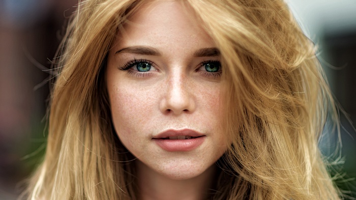 Portrait of a young woman with blonde hair and green eyes