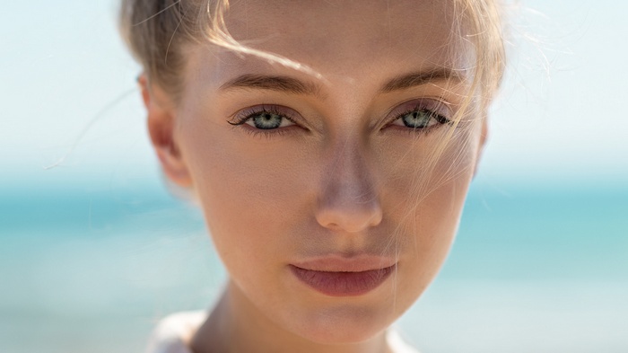 Close-up portrait of a blonde woman with green eyes