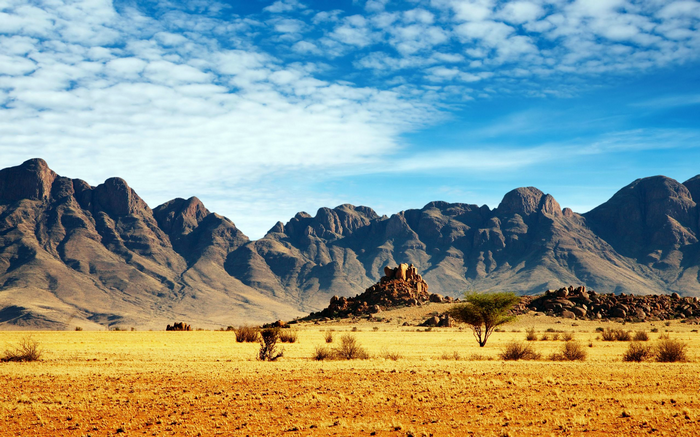 Desert mountains under a cloudy blue sky