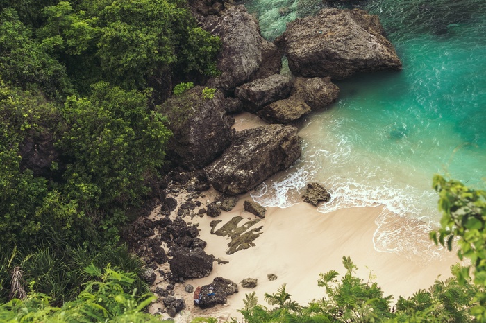 Rocky beach with turquoise water and green trees