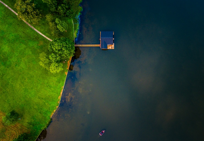 Aerial view of a house on a lake with a boat