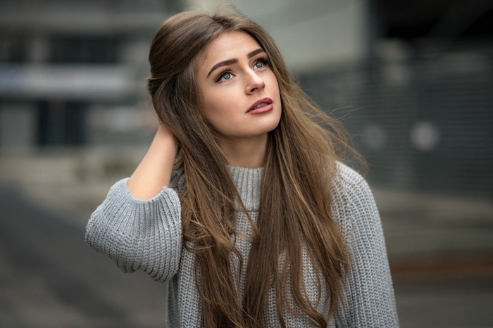 Anna with hands on head wearing grey sweater