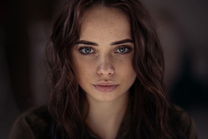 Portrait of a young woman with freckles and gray eyes
