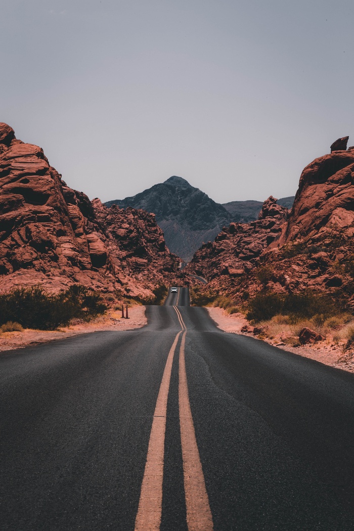 Road through Valley of Fire State Park with red rocks and mountains