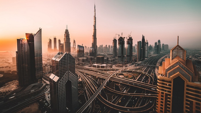 Dubai cityscape with Burj Khalifa and highway interchange at sunset