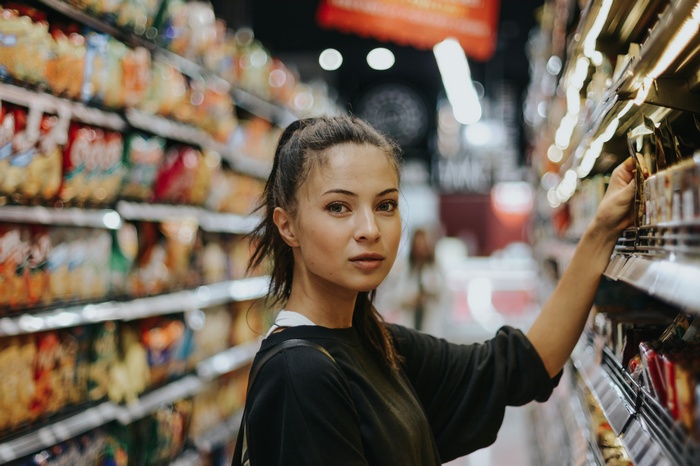 Woman shopping in a grocery store aisle