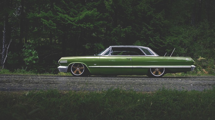 Green Chevrolet Impala parked on a dirt road