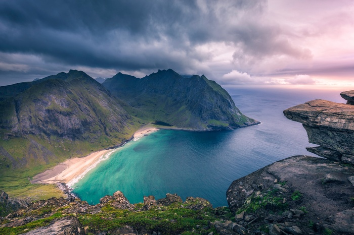 Dramatic coastal mountains and beach with stormy clouds