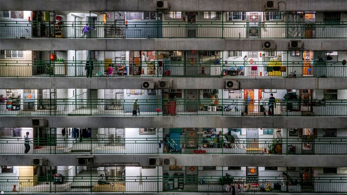 Apartment building balconies with people and lights at night