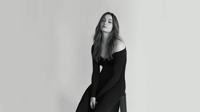 Sophie Turner sitting on a stool