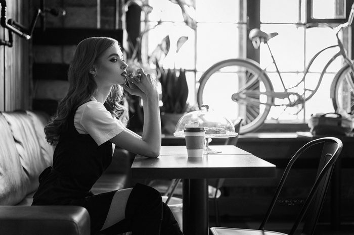 Woman in cafe with bicycle in background