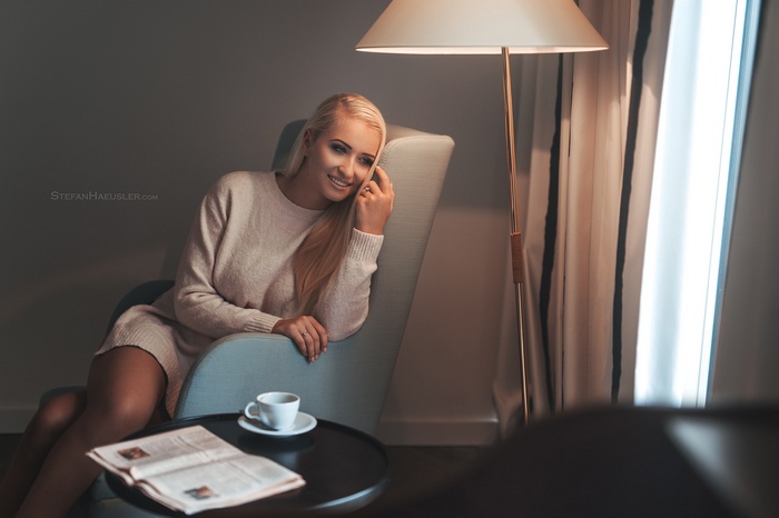 Woman sitting in a chair with a lamp and coffee