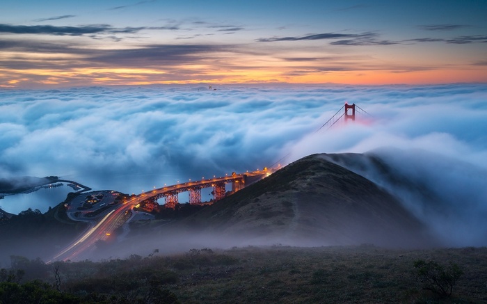 Golden Gate Bridge shrouded in fog at sunrise