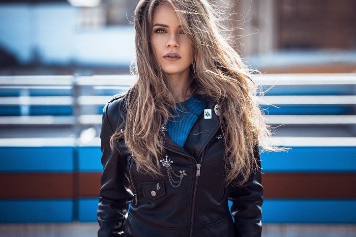 Woman with long blonde hair wearing a leather jacket