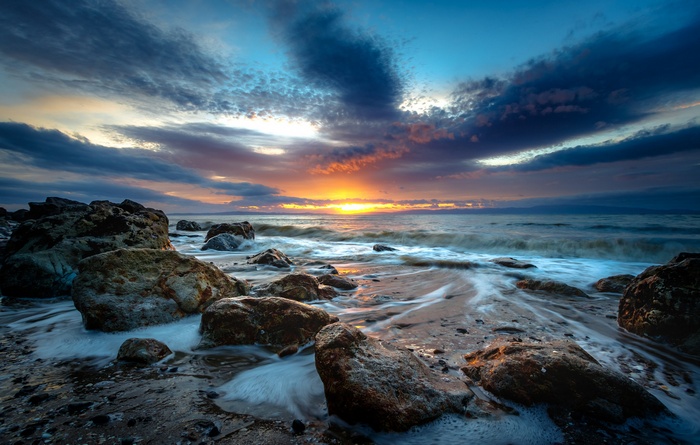 Sunset over a rocky coast with waves