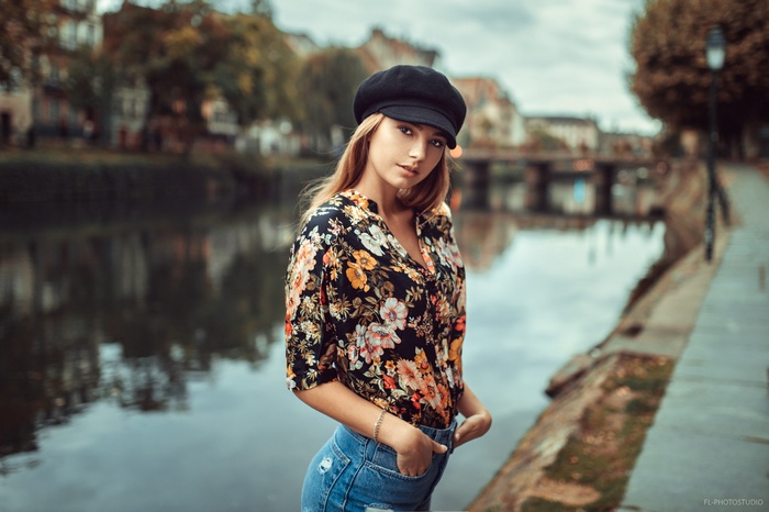 Woman in floral shirt and denim shorts by river