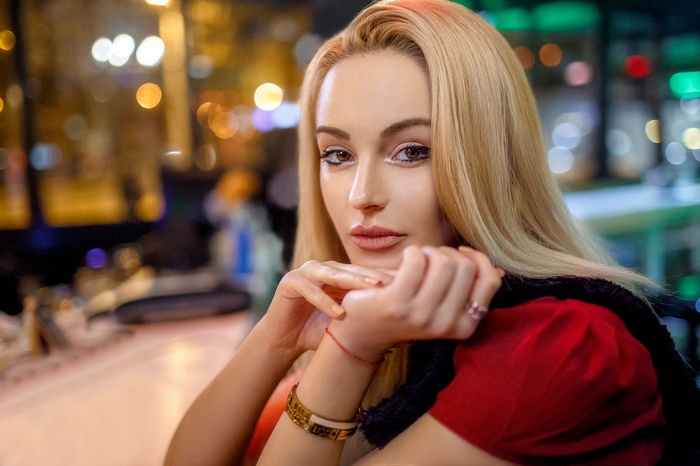 Blonde woman with hands on chin