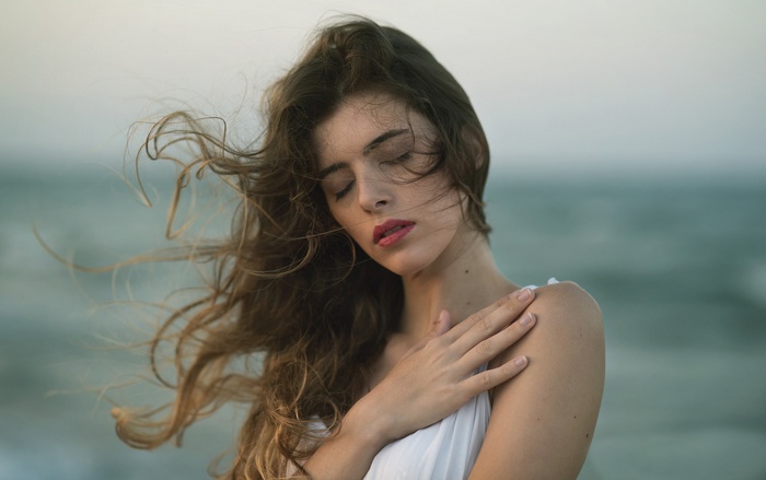 Woman with windblown hair by the sea