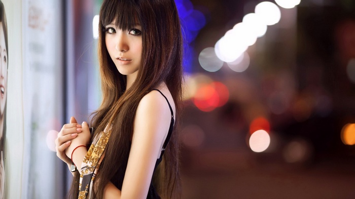 Asian woman with long brown hair at night