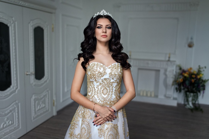Woman in a white and gold dress with a tiara