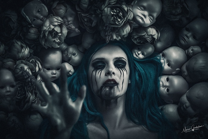 Woman surrounded by doll heads and flowers