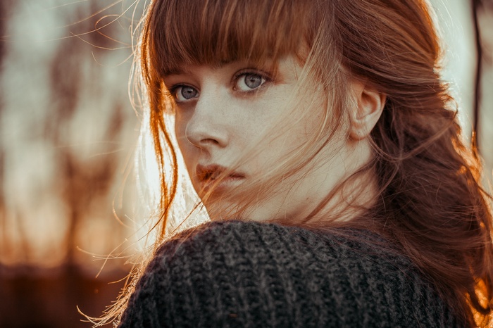 Young woman with red hair wearing a sweater