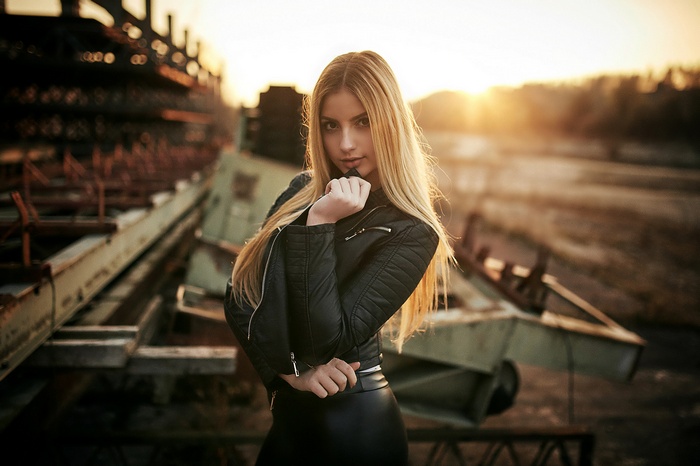 Woman in black leather jacket outdoors at sunset