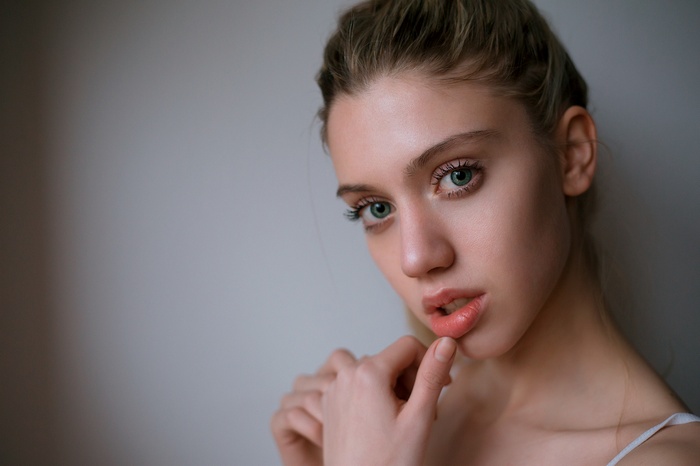 Woman with green eyes and finger on lips