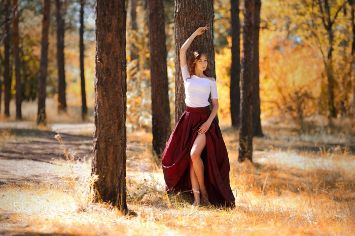 Woman in a red skirt in a forest