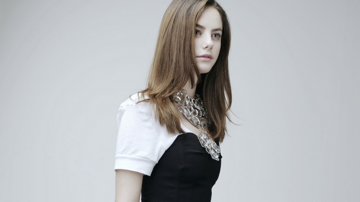Kaya Scodelario wearing a black dress and white top with necklace
