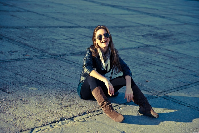 Lily C laughing outdoors wearing sunglasses and leather jacket