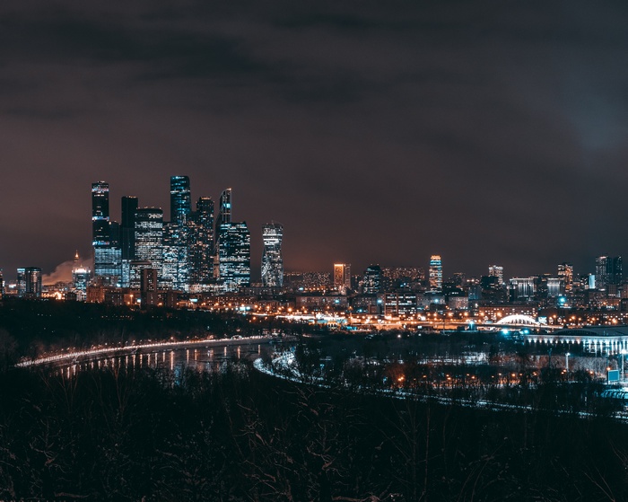 Moscow City skyscrapers at night with river