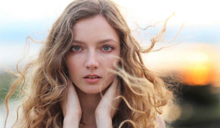 Woman with wavy blonde hair and gray eyes