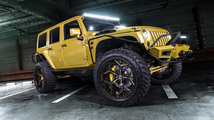 Yellow Jeep Wrangler with custom wheels and lights