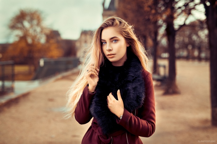 Woman with blonde hair and blue eyes in a red coat