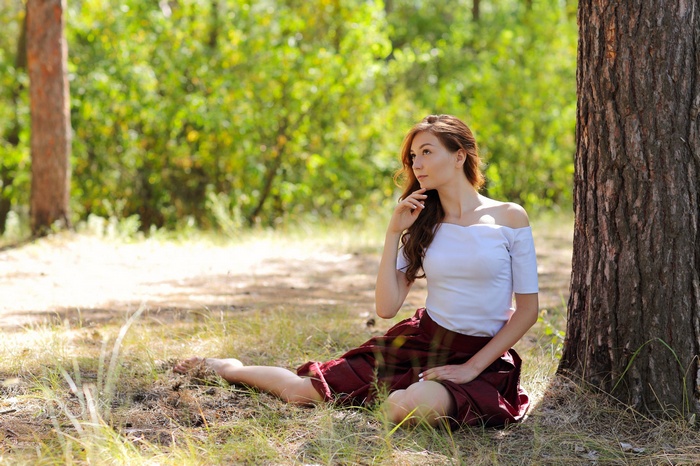 Woman with long hair sitting in a forest