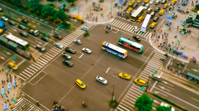 Tilt-shift view of a busy city intersection with traffic
