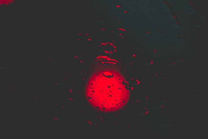 Red circle with water drops on dark background