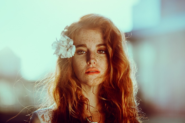 Woman with freckles and a flower in her hair