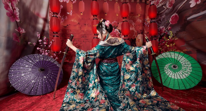 Woman in kimono holding katanas with umbrellas